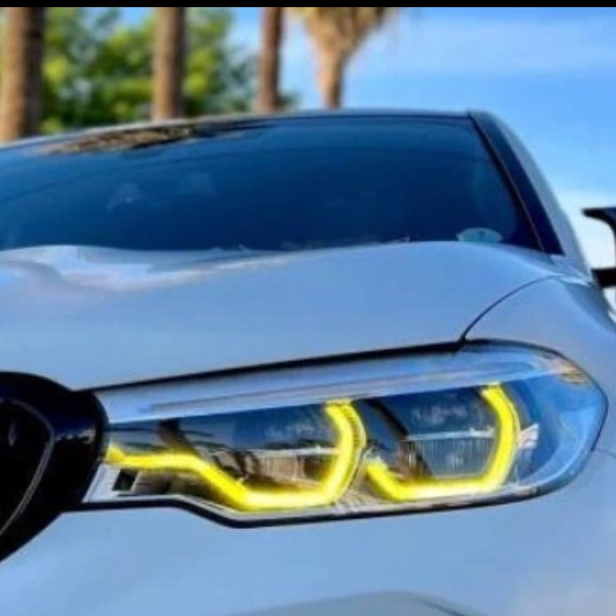 BMW with yellow DRL angel eyes at sunset